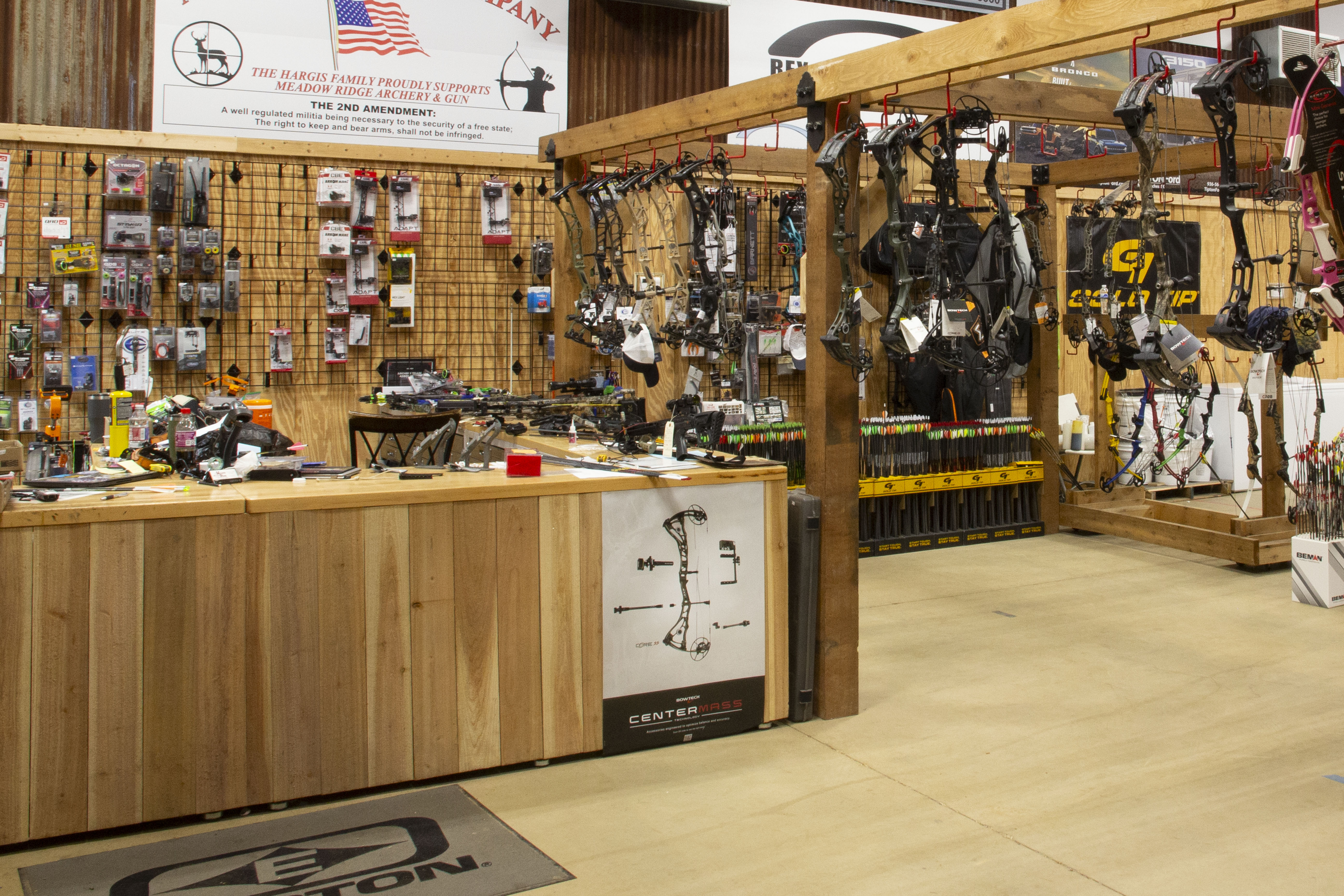 Archery pro shop desk surrounded by bows and accessories.